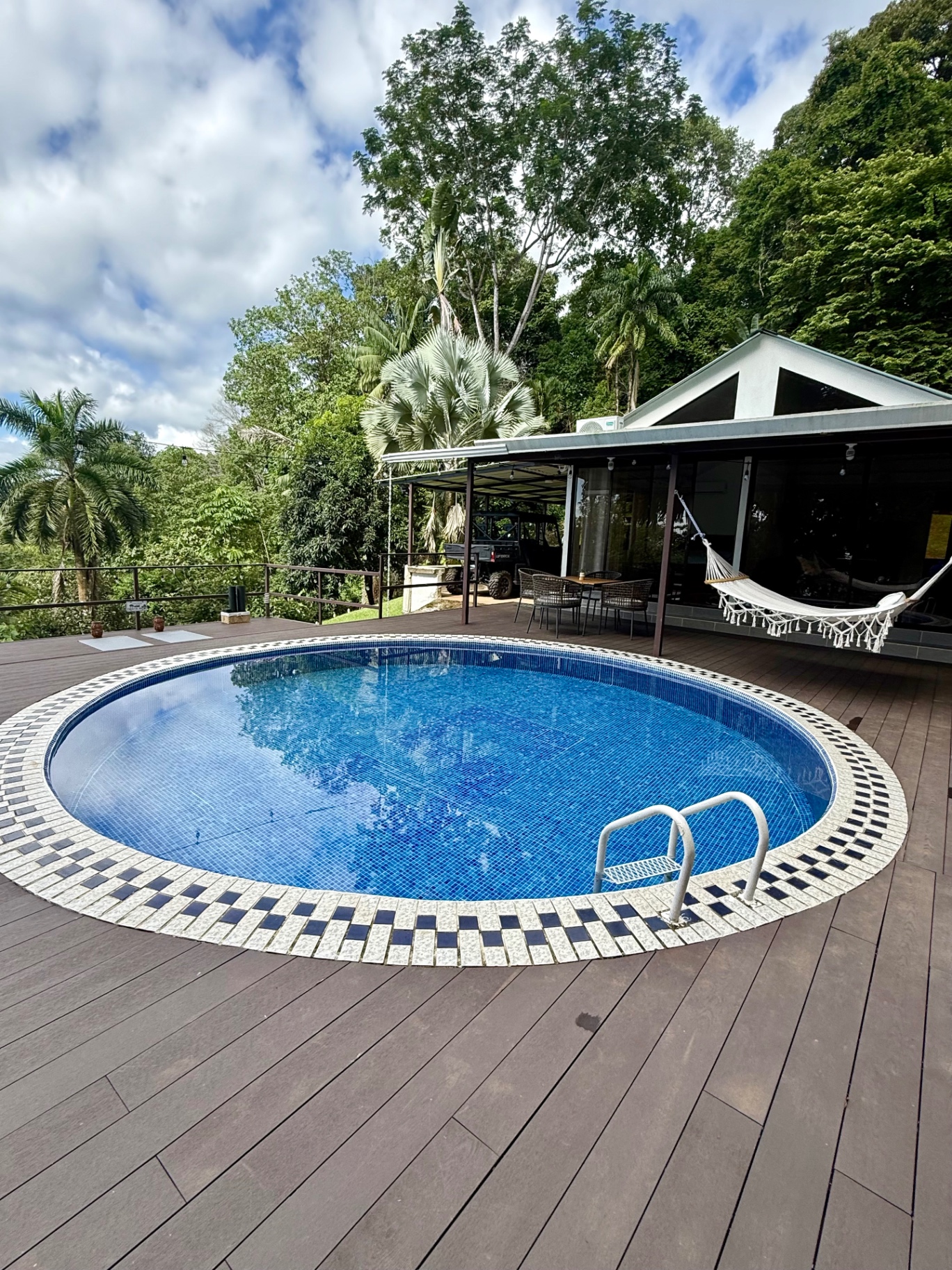 Piscina redonda en el deck rodeada de selva