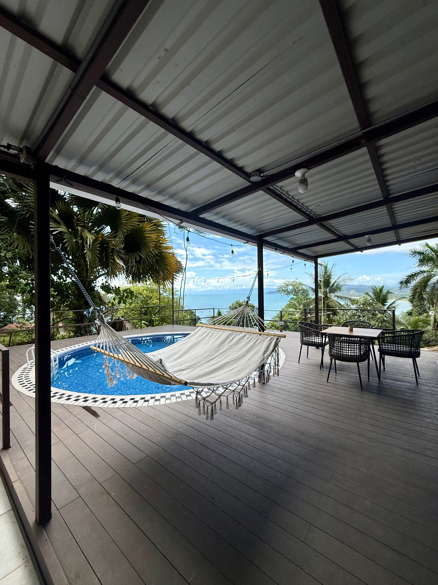 Deck cubierto con hamaca y piscina frente al mar