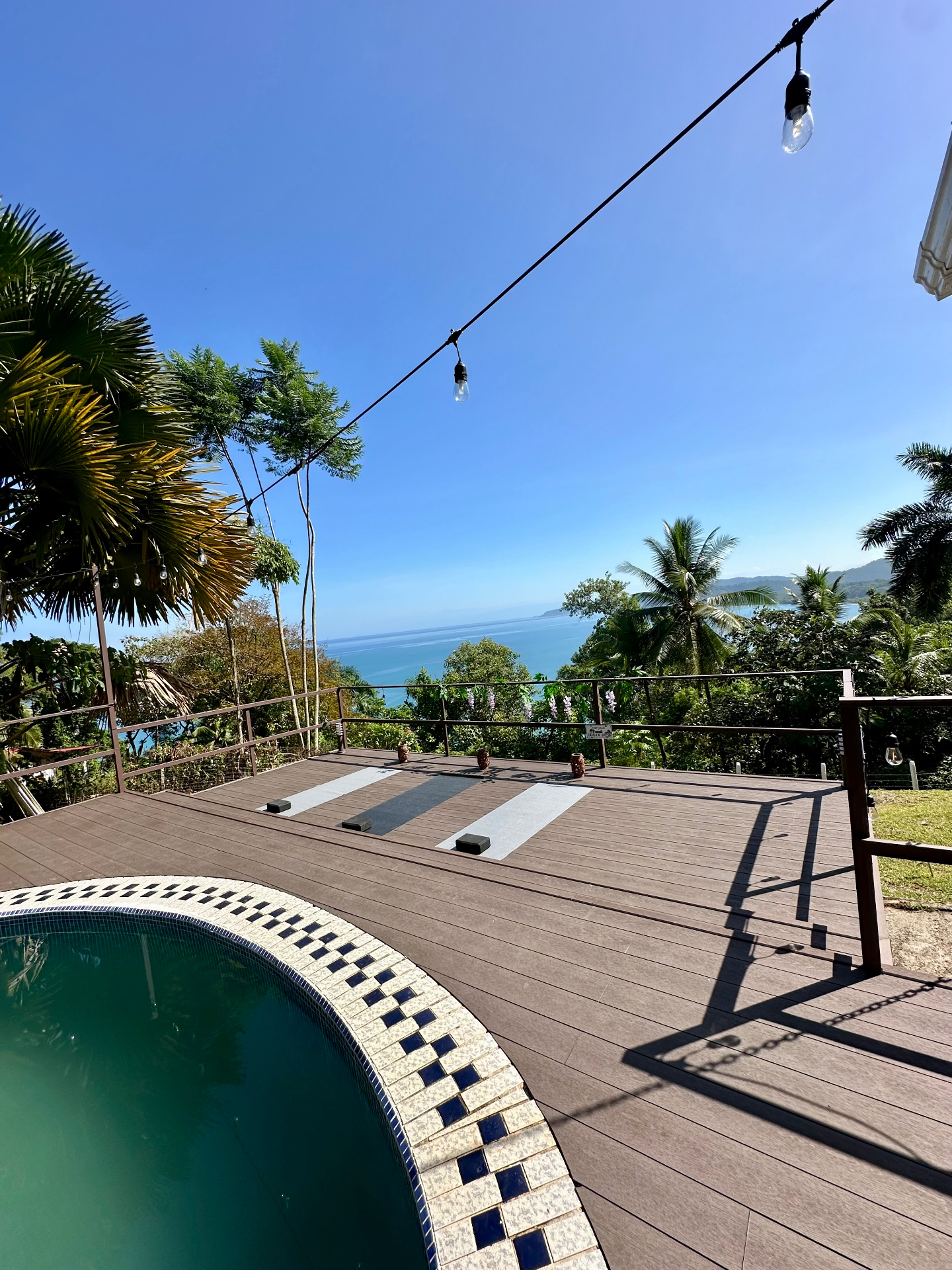 Deck de yoga junto a la piscina con vista al océano
